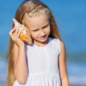 Girl listening to a shell