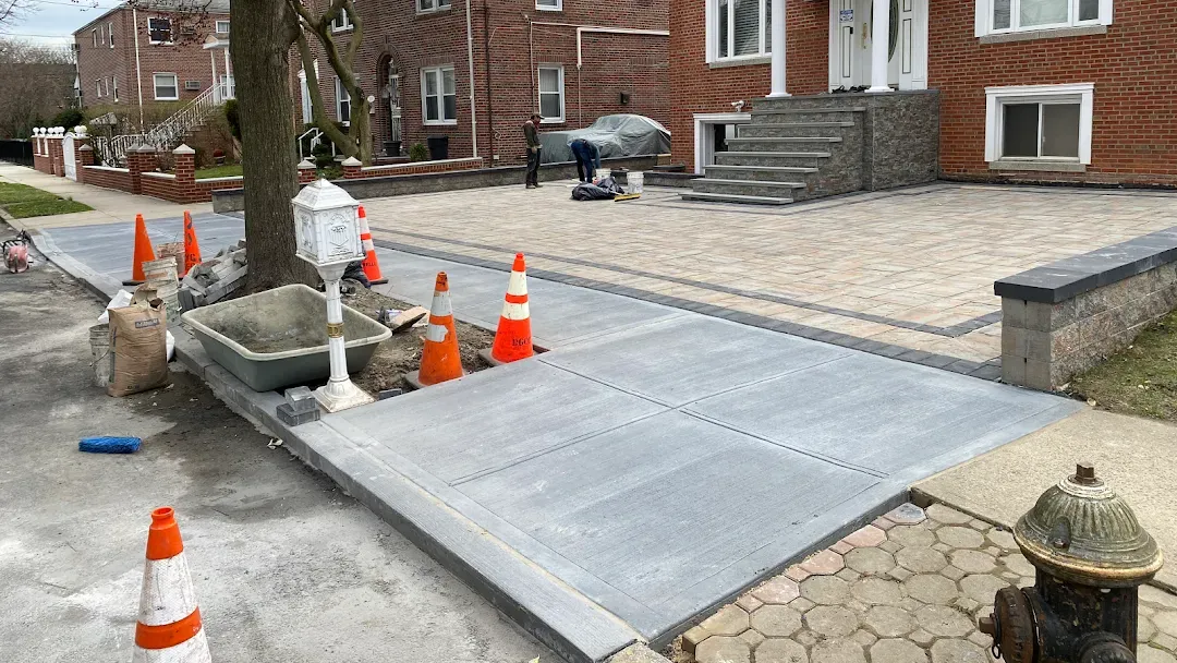 Newly built residential sidewalk and renovated driveway in a construction zone in Queens, New York.
