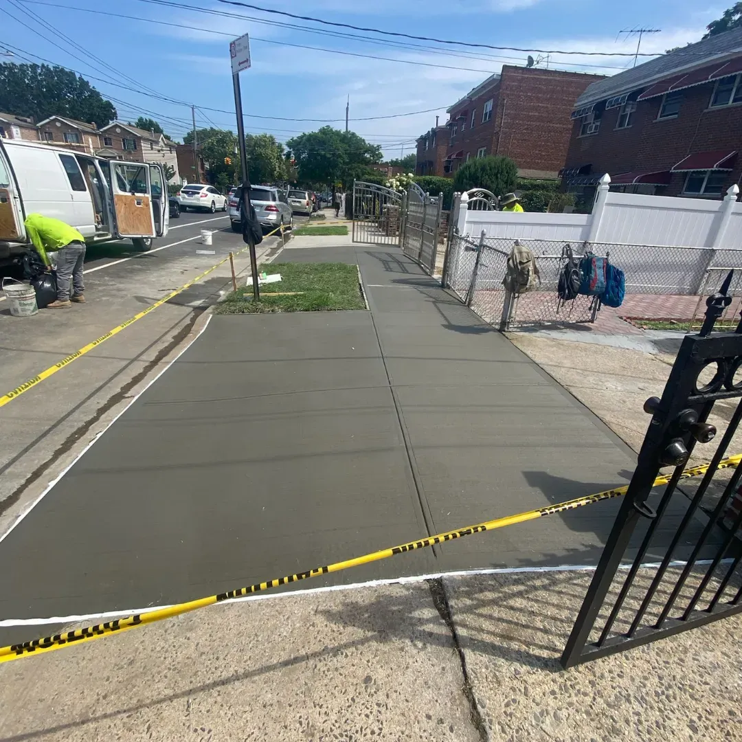Newly constructed concrete sidewalk on a residential street in Queens, New York.