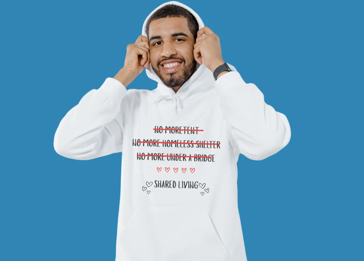 A charcoal gray hoodie with a minimalist mountain and sun logo, displayed on a mannequin in front of a window with natural light. The background is soft and uncluttered, emphasizing the garment's details.