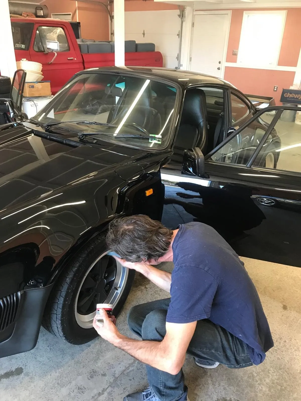 MarMax detailer hand-cleaning a wheel on a black sports car