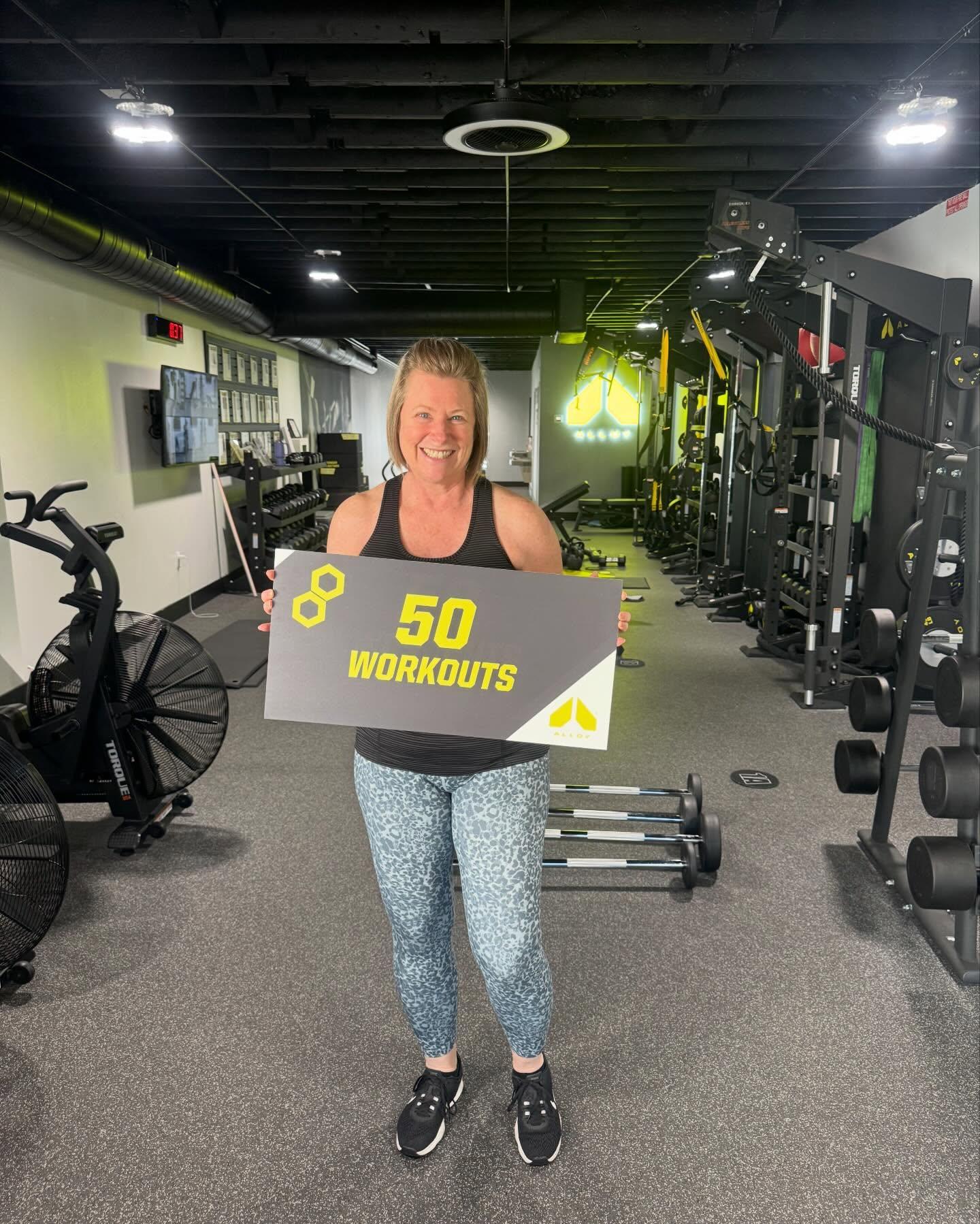 Woman celebrating her 50th workout milestone at Alloy Personal Training South Tampa with small group fitness training. Focused on strength training, mobility, and consistency for adults over 40.