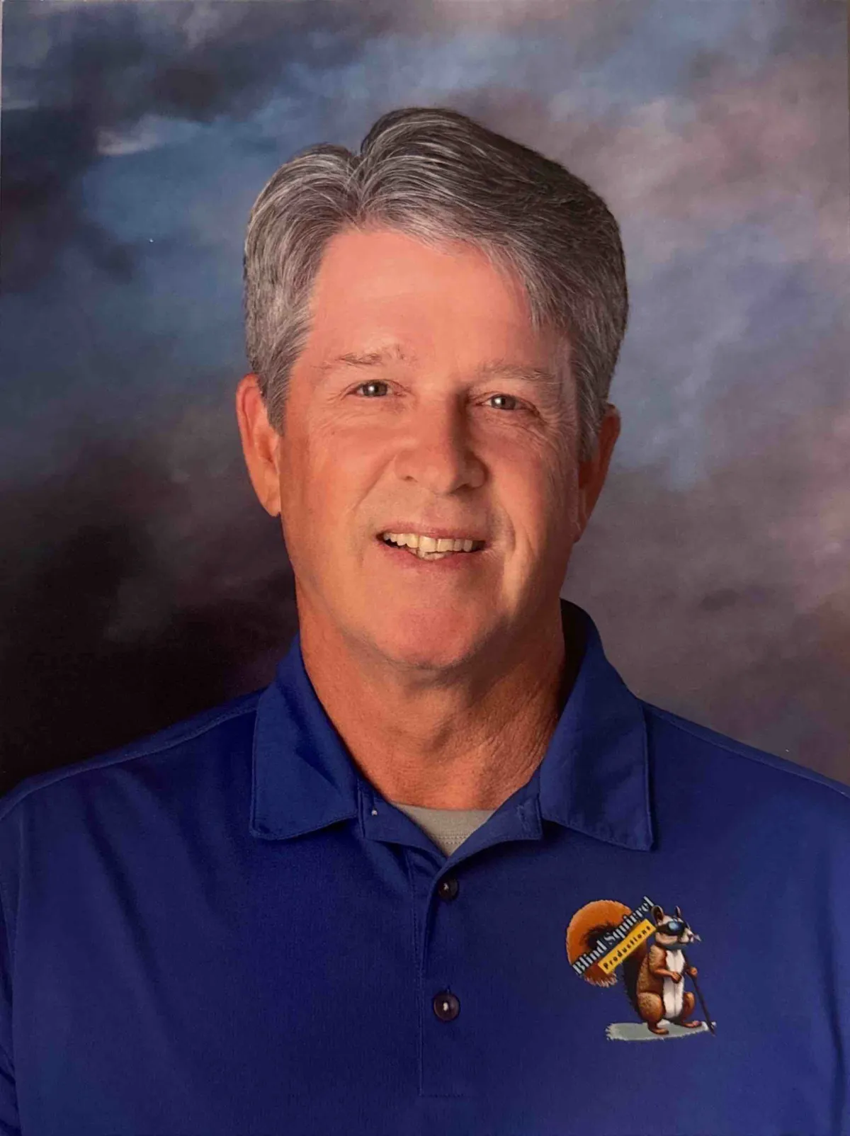 Cutout portrait of Coach Connelly in his red 'ALTA' baseball jersey, smiling.
