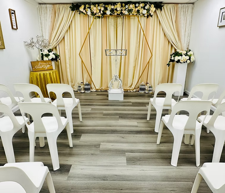 Bright intimate wedding chapel with white chairs and floral accents