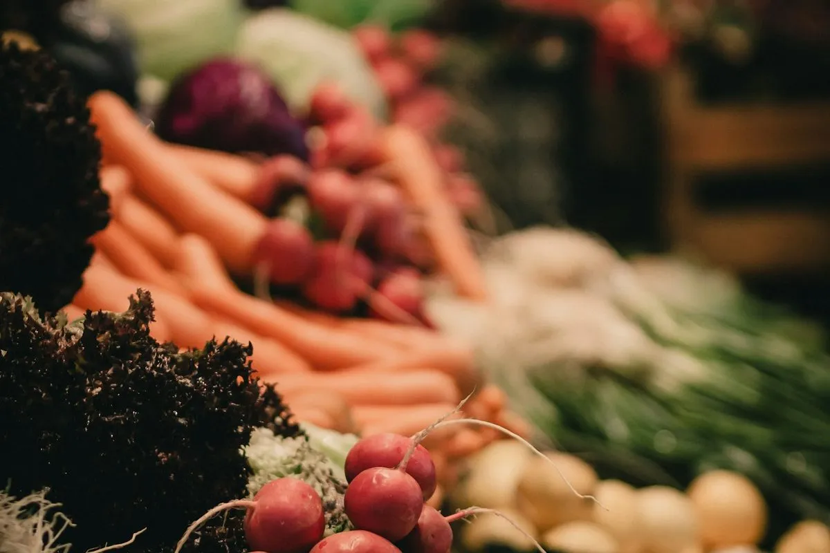 Carrots and fresh produce at a farmers market stall