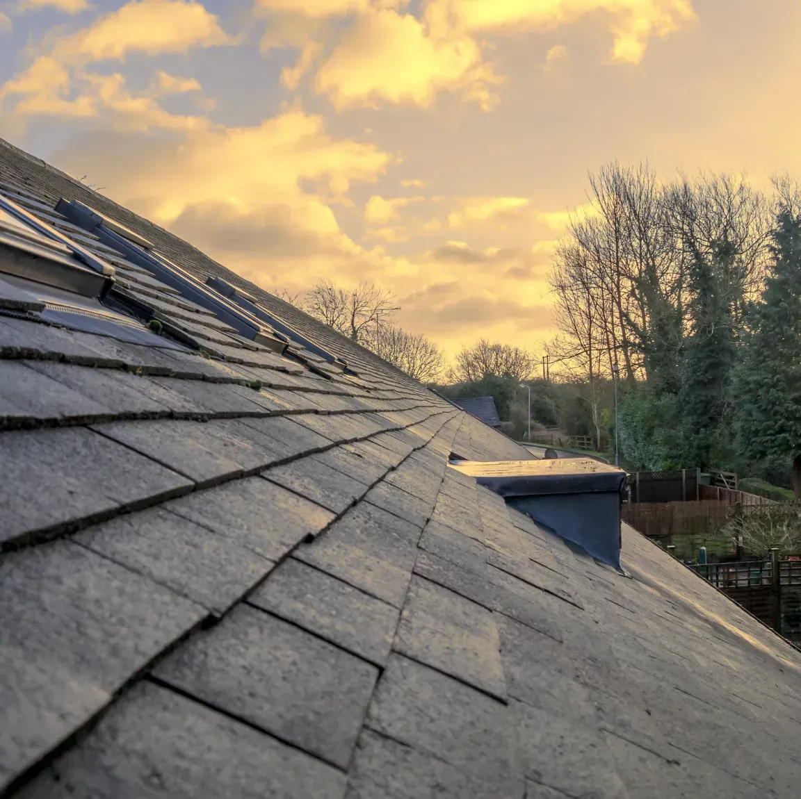 Roofing contractor repairing damaged shingles and restoring a residential roof in Lynn, Massachusetts.