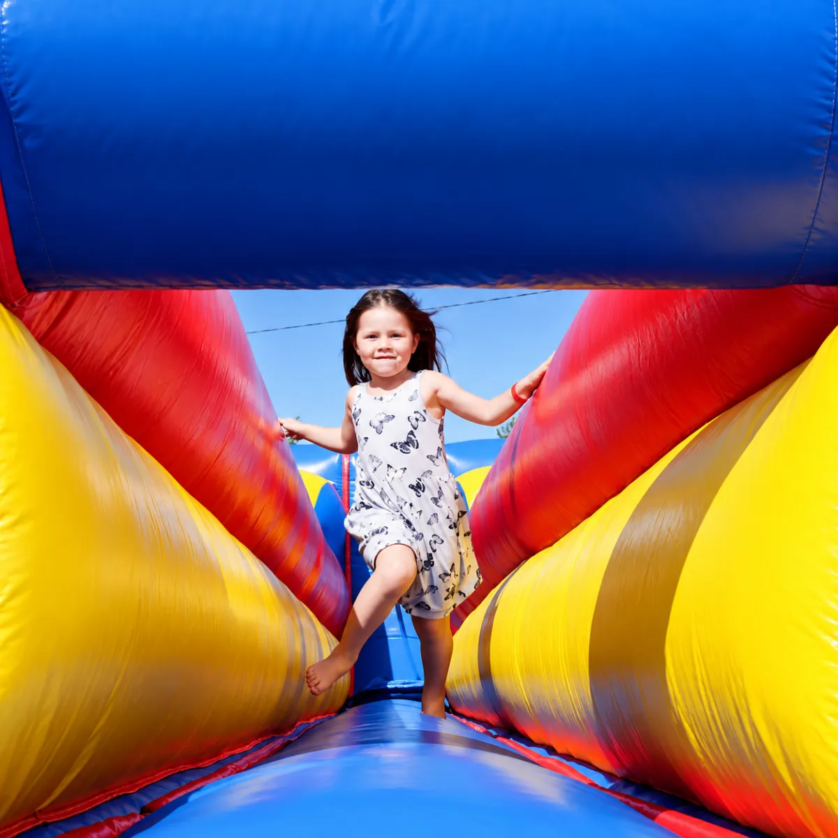 Child running in front of a bounce house with bubbles (Family Fun)