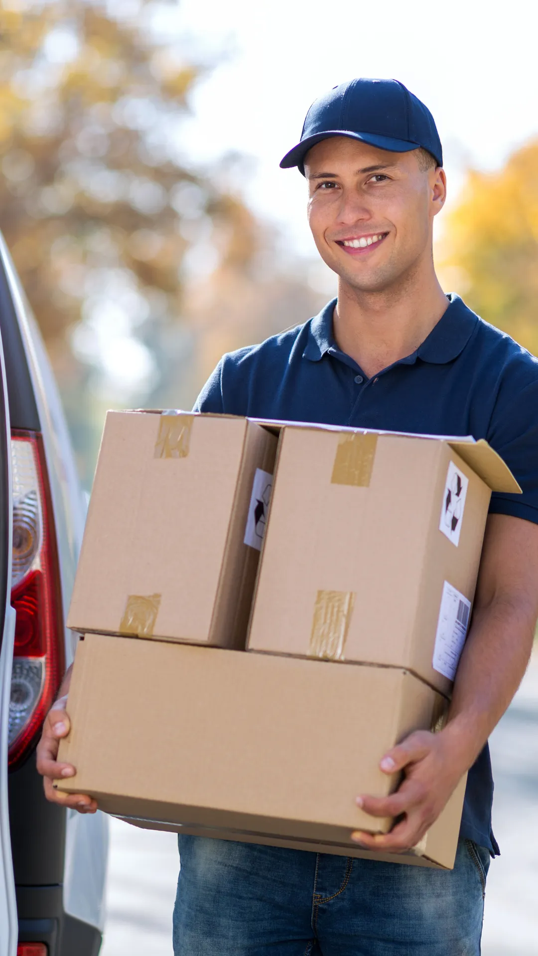 A white delivery truck driving down a street
