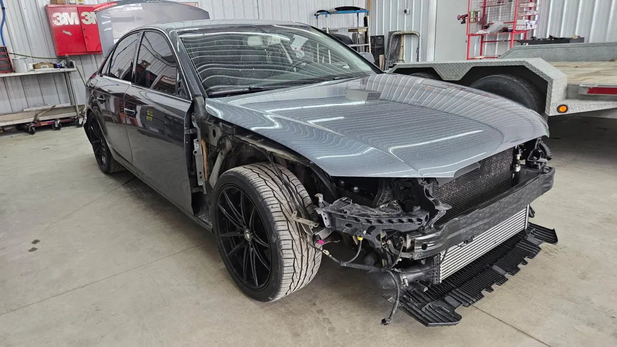 Dark sedan with front collision damage awaiting certified body repair at Legacy Automotive, Hastings, MI