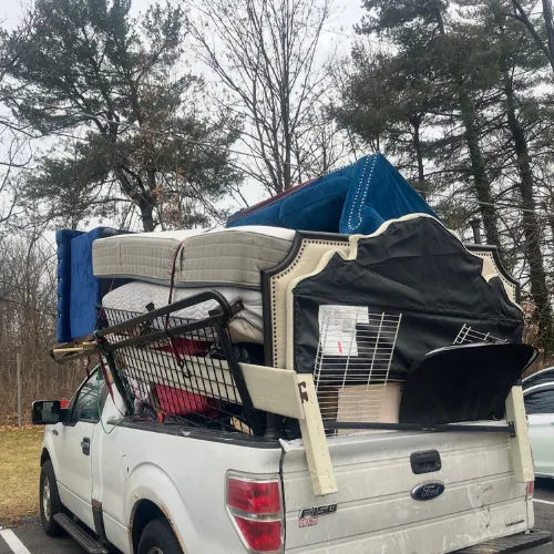 A white truck with a large brown container is parked.