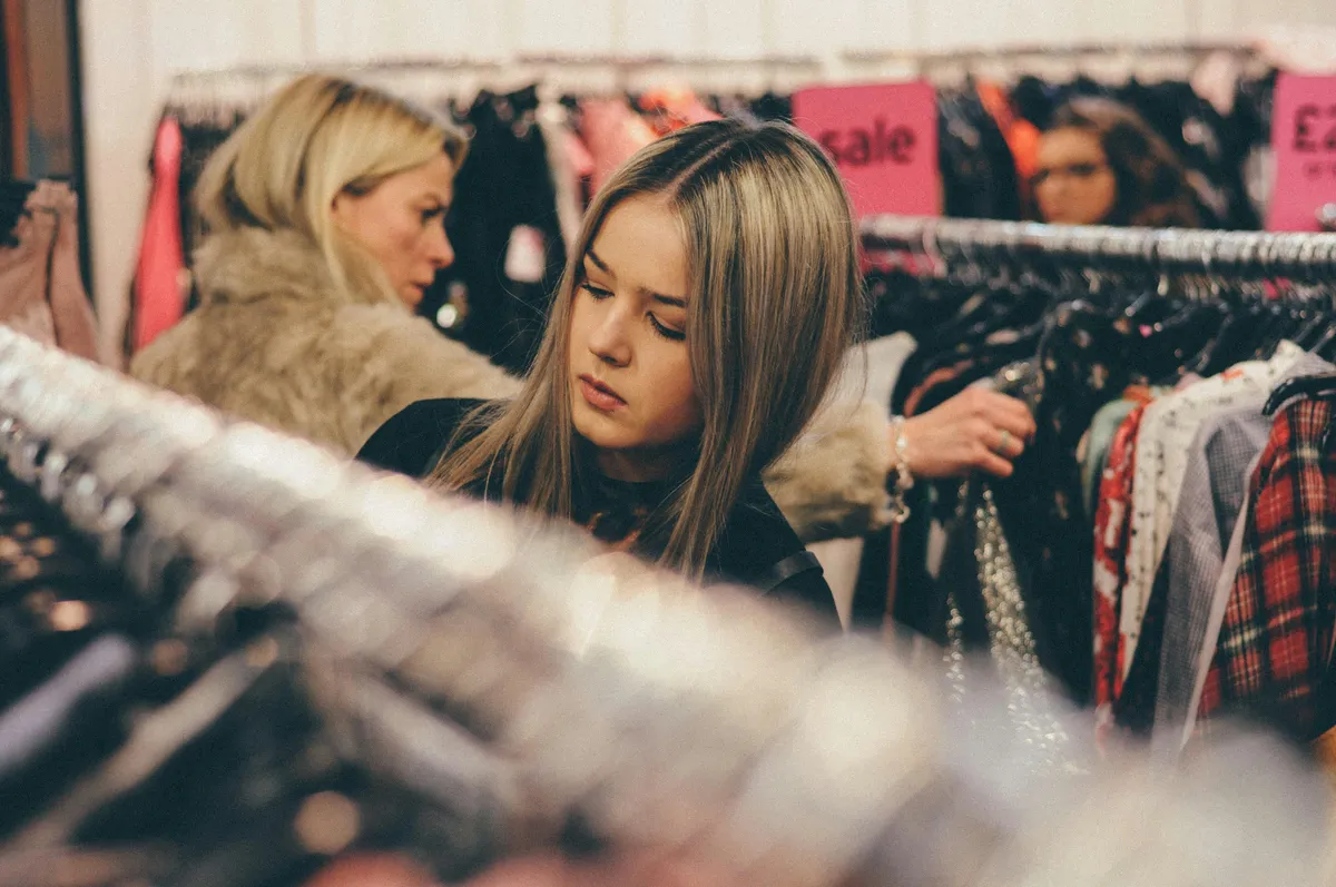 Woman browsing clothing racks while shopping