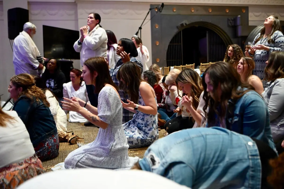 A crowd of people with hands raised in excitement.