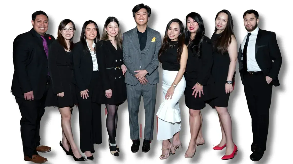 A group of eleven stylishly dressed individuals posing together, showcasing formal attire in black and white, with fashionable accessories.