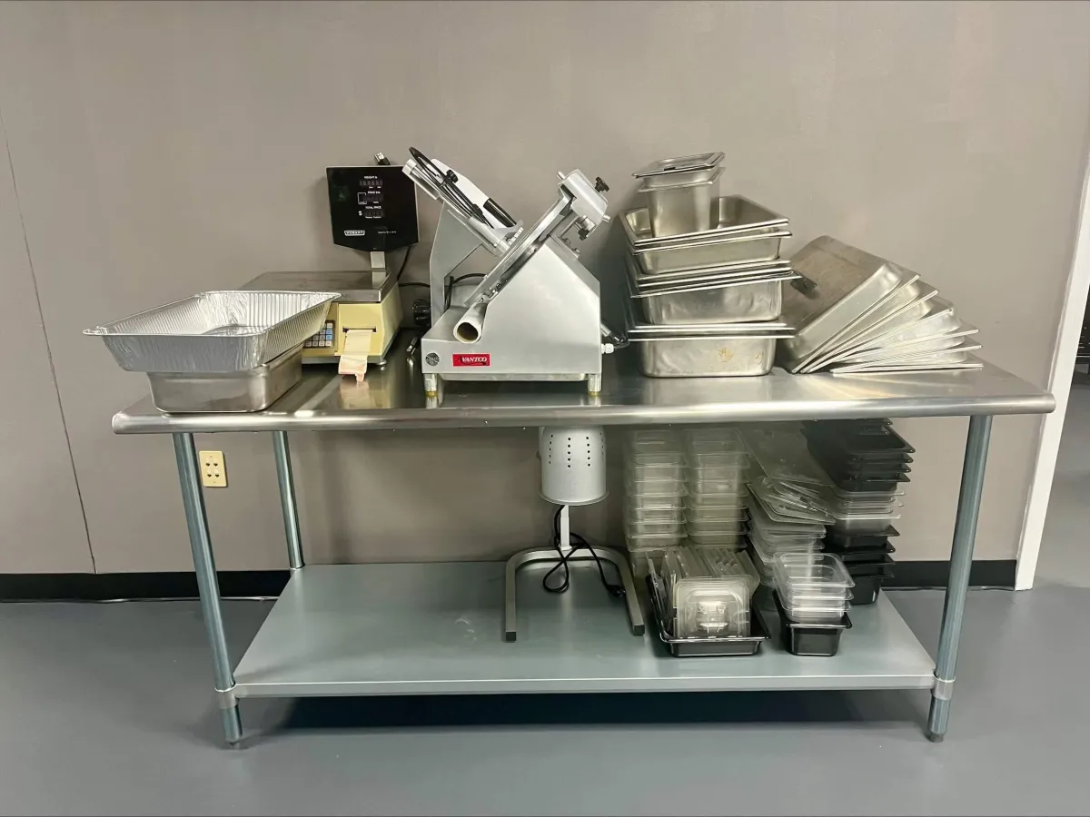 Man holding red peppers in a kitchen.
