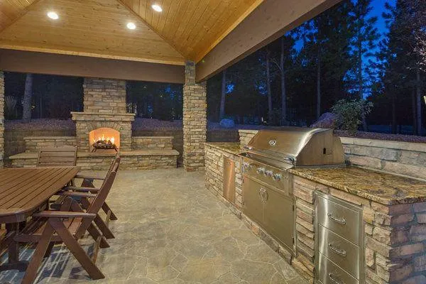 Custom outdoor stacked stone fireplace and BBQ grill kitchen space