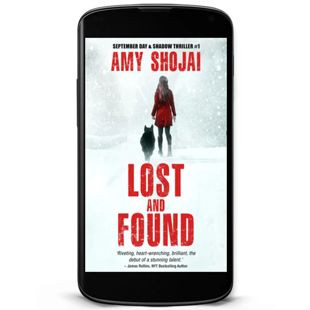 Book Cover: Lost and Found by Amy Shojai. A woman in a red winter coat with a black dog by her side stands in a winter storm looking out into the white blowing snow.