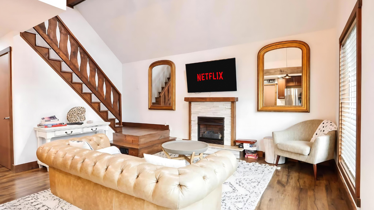 Intimate interior: lower-level living room staged for a strategy session with large-screen SMART TV, minimalist neutral palette, soft natural light through tall windows, photorealistic style conveying privacy and productive comfort.