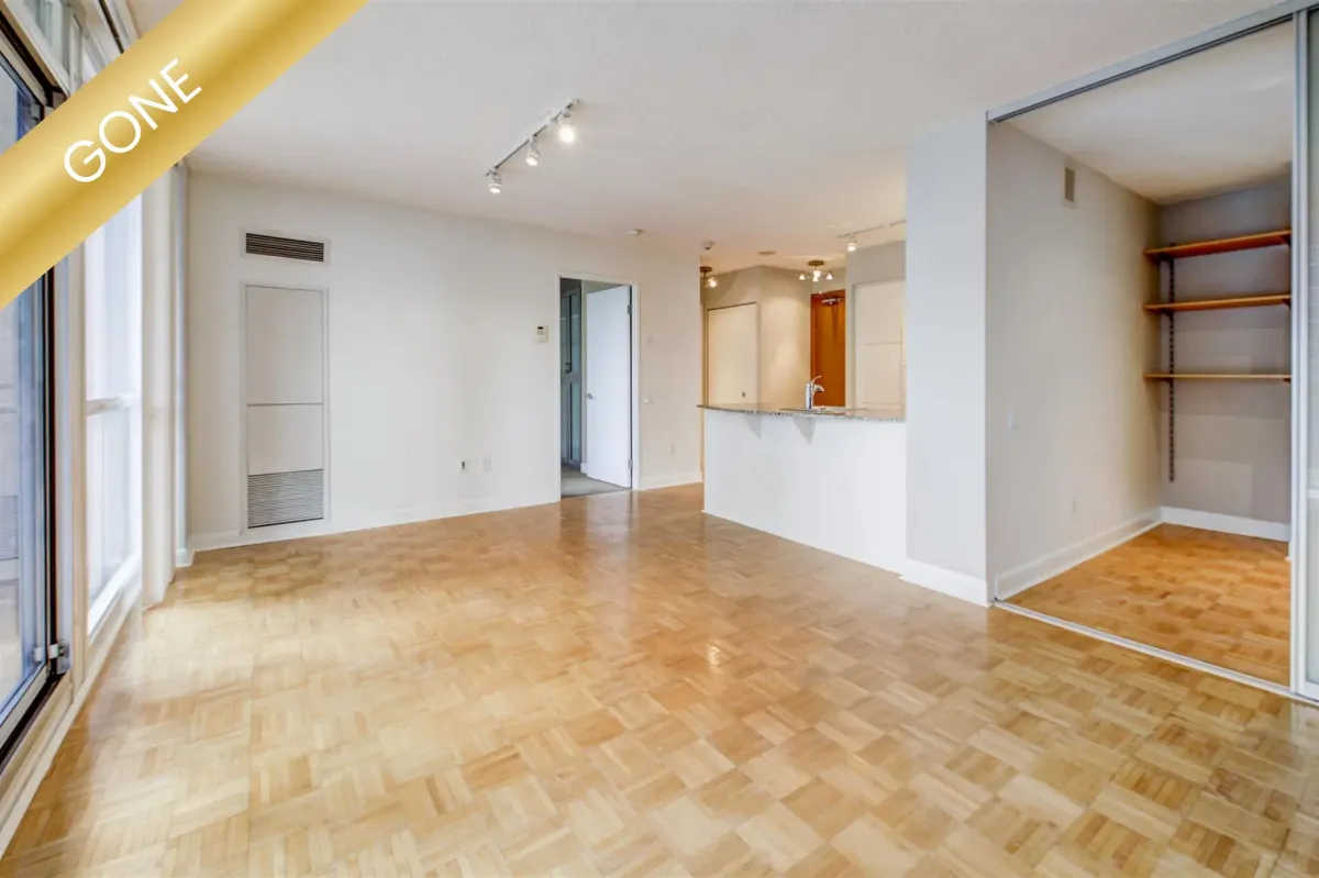 Warm and inviting residential living room at 35 Sheppard Ave E #707, Toronto, Ontario, featuring a stone fireplace and large window.