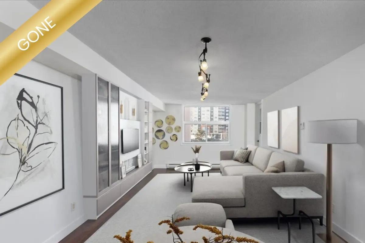 Professional interior view of a residential condo at 175 Deerfield Rd #1007, Newmarket, Ontario, featuring dark leather furniture and hardwood floors.