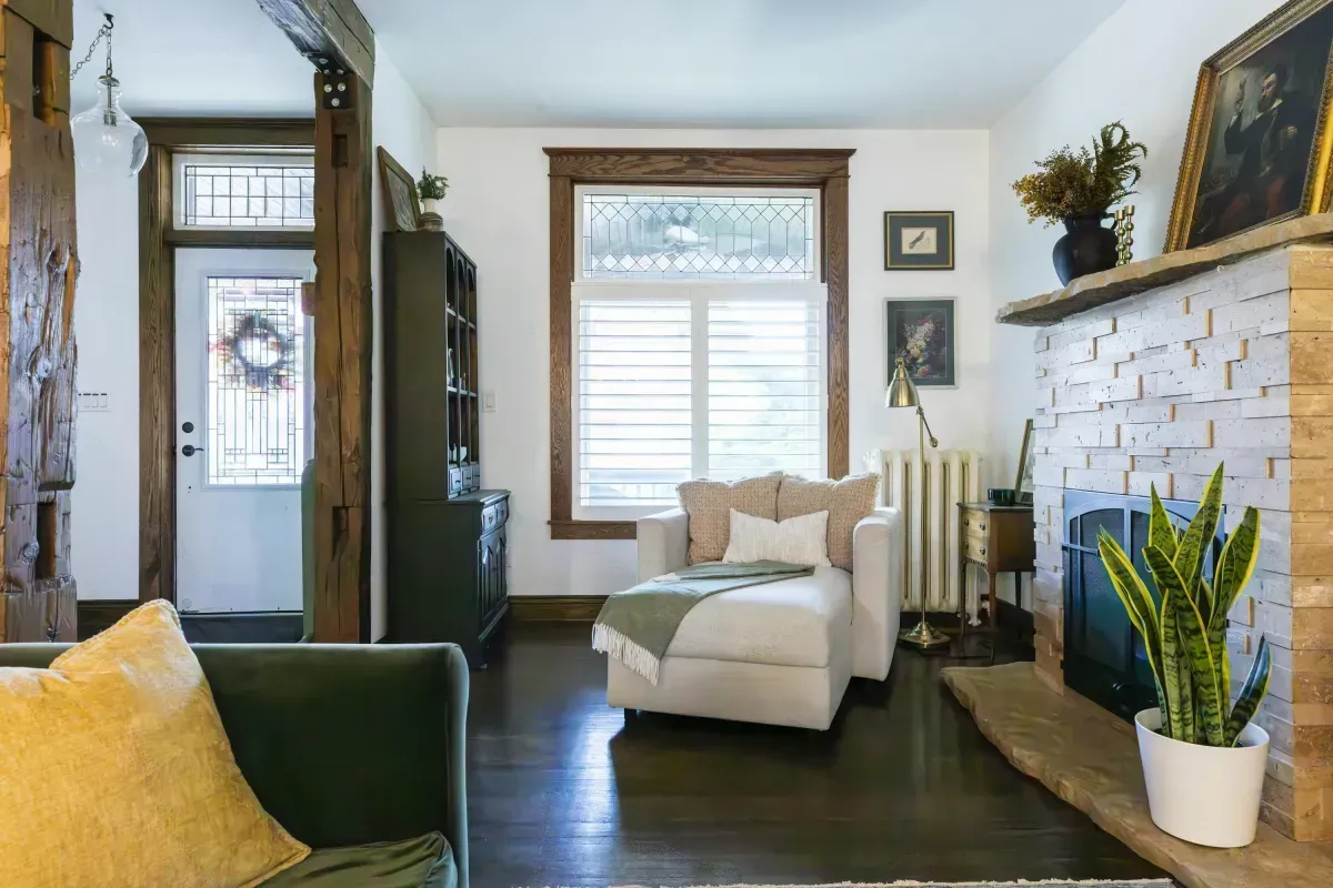 Front living room at 109 Fairleigh Ave S Hamilton featuring restored original hardwood floors, gas fireplace, with natural light.
