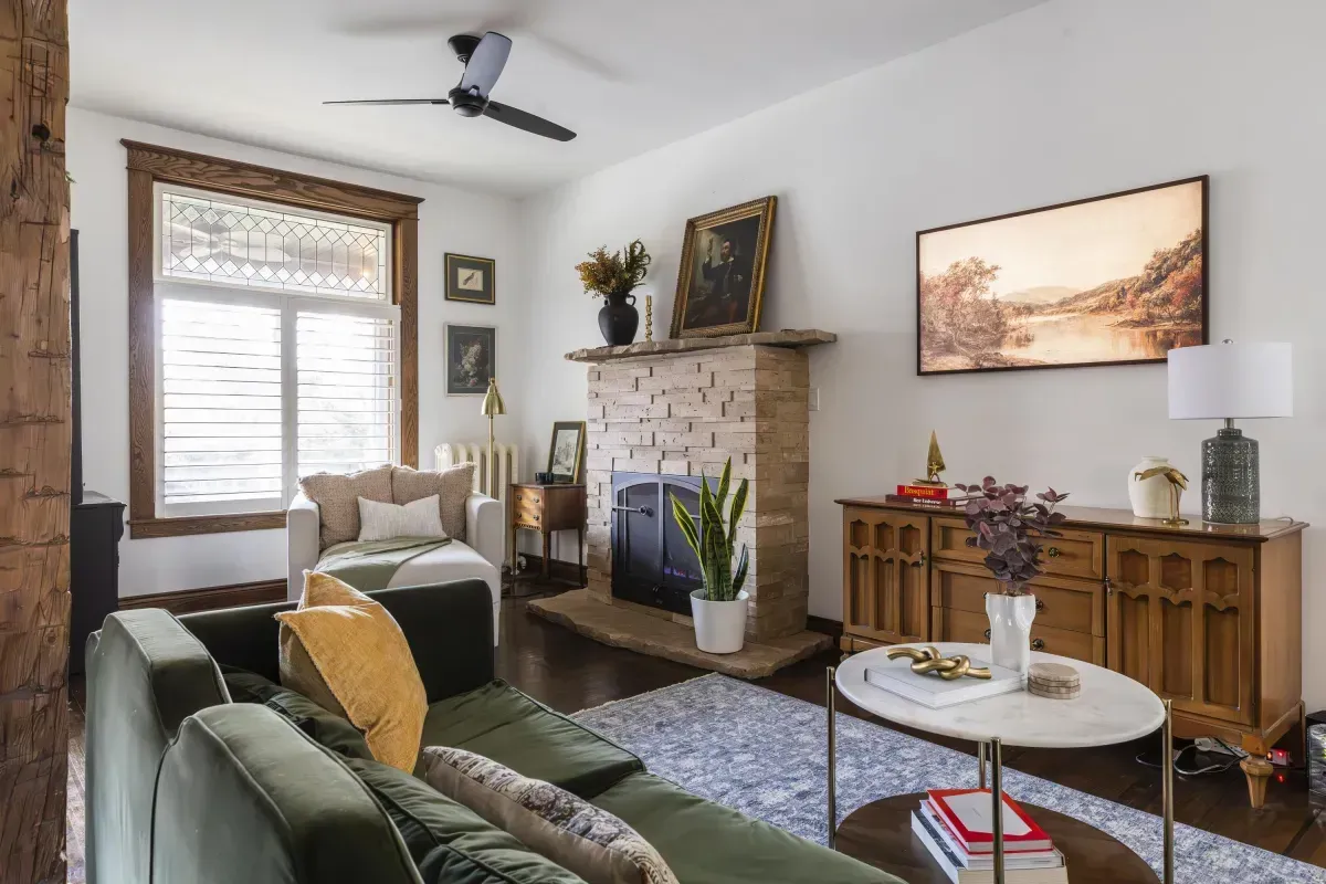 Front living room at 109 Fairleigh Ave S Hamilton featuring restored original hardwood floors, gas fireplace, with natural light.