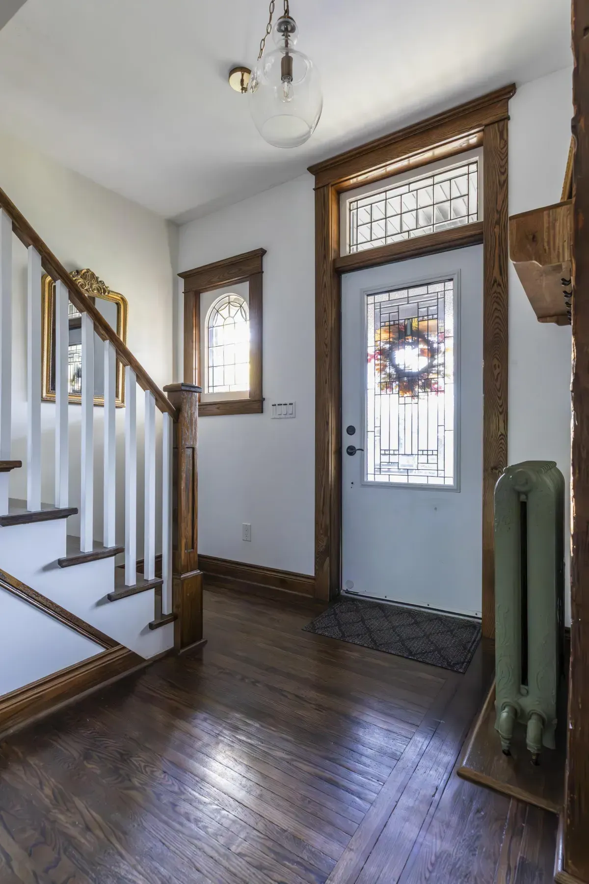 Front living room at 109 Fairleigh Ave S Hamilton featuring restored original hardwood floors, gas fireplace, with natural light.