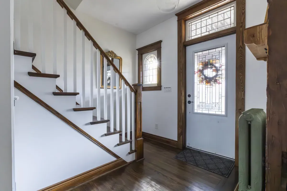 Front living room at 109 Fairleigh Ave S Hamilton featuring restored original hardwood floors, gas fireplace, with natural light.