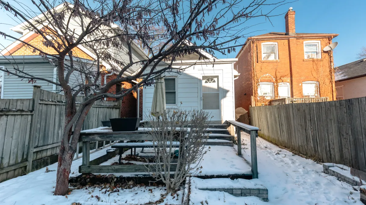 Private fully fenced-in backyard at 81 Lambton Ave featuring an expansive wooden deck and oversized storage shed.