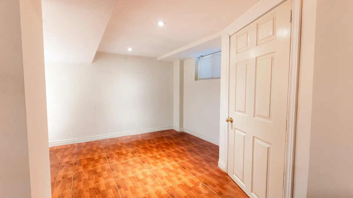 Versatile finished basement at 81 Lambton Ave with durable tile flooring, ideal for a 3rd bedroom or media room.