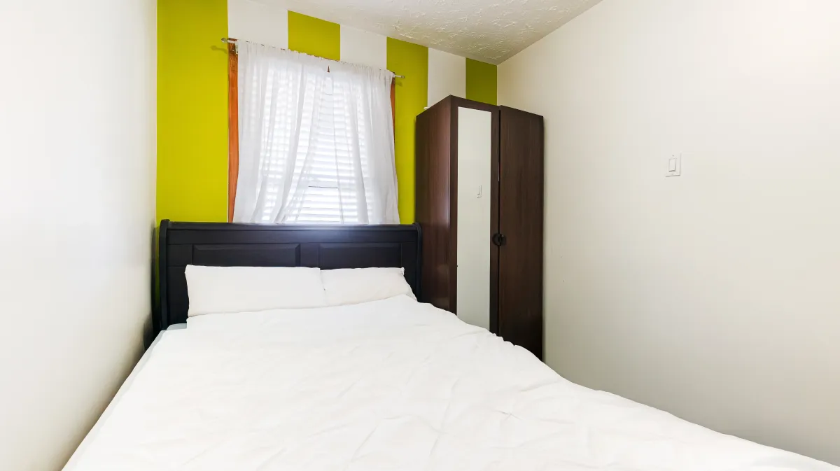 Well-proportioned main floor bedroom at 81 Lambton Ave with natural light and hardwood floors.