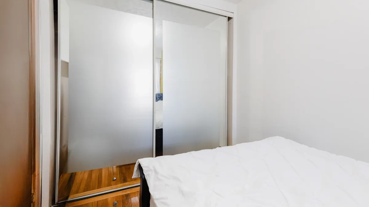 Well-proportioned main floor bedroom at 81 Lambton Ave with natural light and hardwood floors.