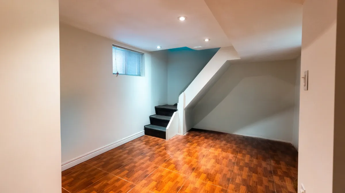 Versatile finished basement at 81 Lambton Ave with durable tile flooring, ideal for a 3rd bedroom or media room.