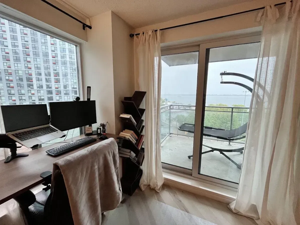Large private balcony at 410 Queens Quay W #812 with glass railings and unobstructed southeast exposure.