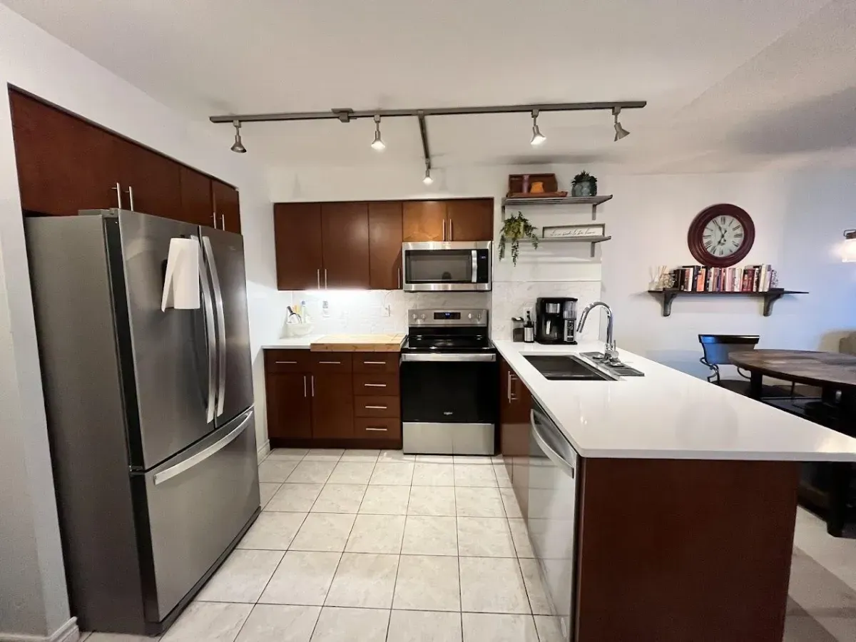 Modern kitchen at 410 Queens Quay W #812 featuring custom maple cabinetry, stainless steel appliances, and a functional pantry.