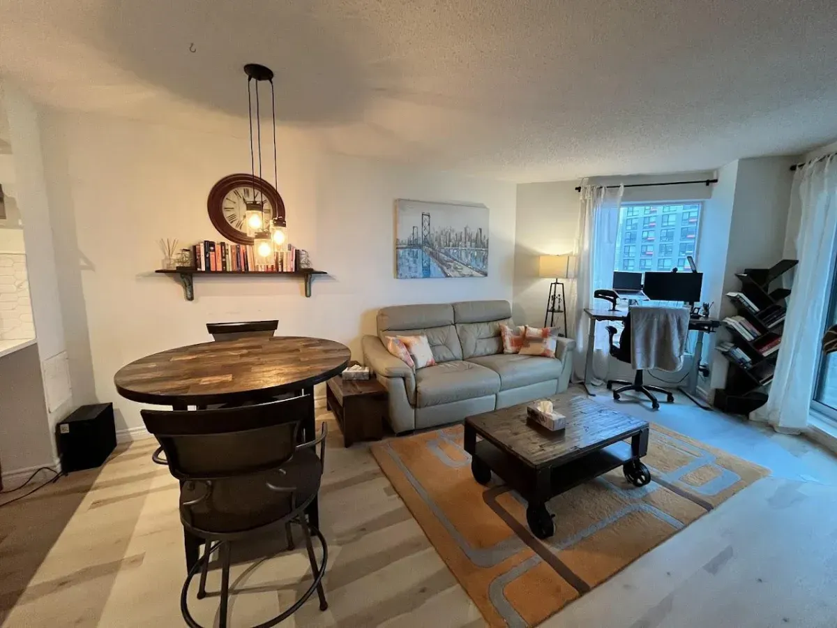 Bright southeast-facing living room with light hardwood floors and an integrated dining area at Aqua condos.