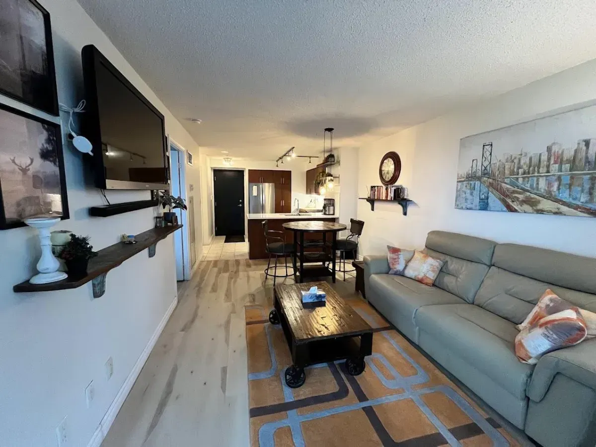 Bright southeast-facing living room with light hardwood floors and an integrated dining area at Aqua condos.