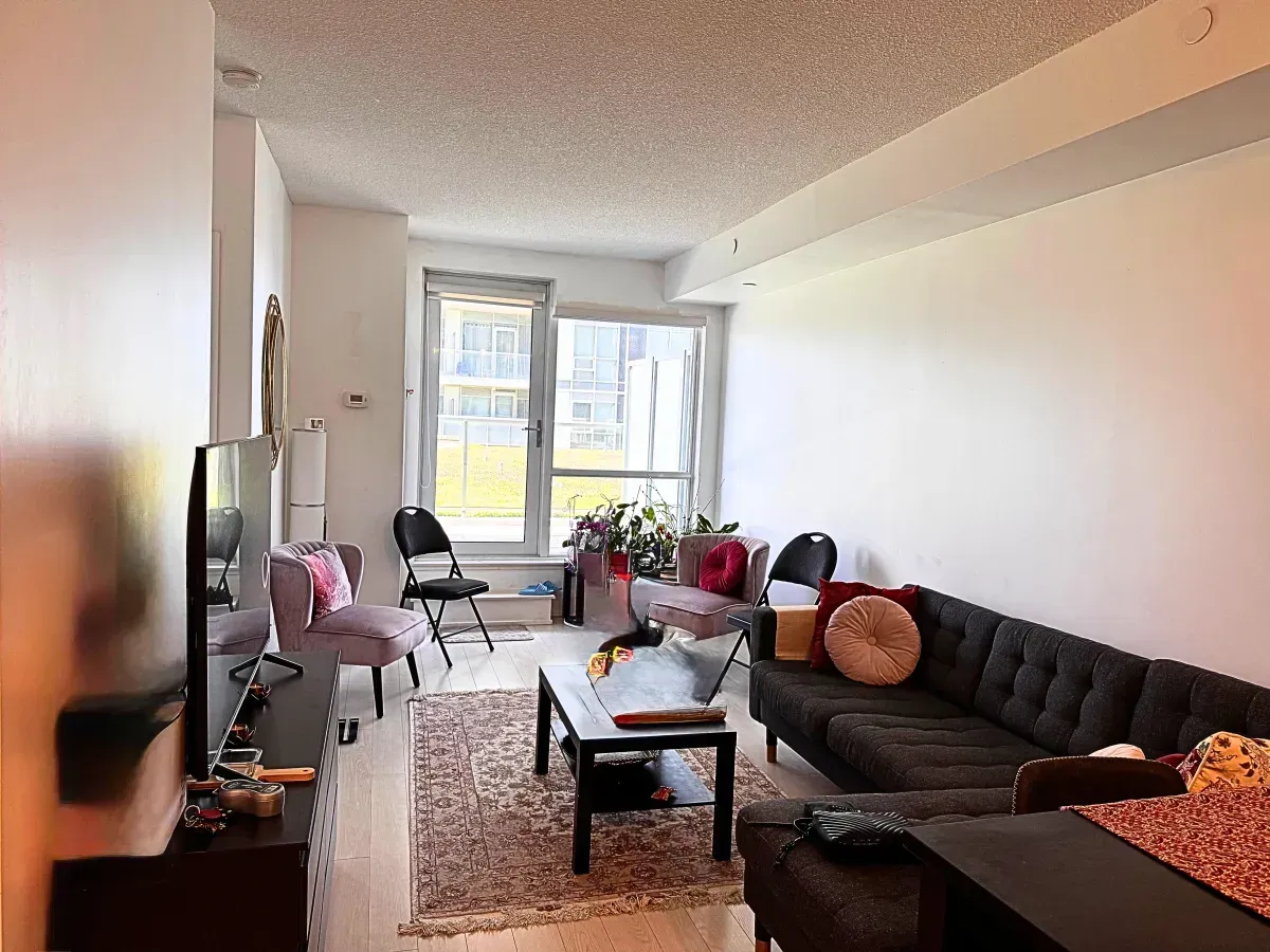 Sun-filled living area at 120 Harrison Garden Blvd #901 featuring floor-to-ceiling windows and modern wide-plank flooring.