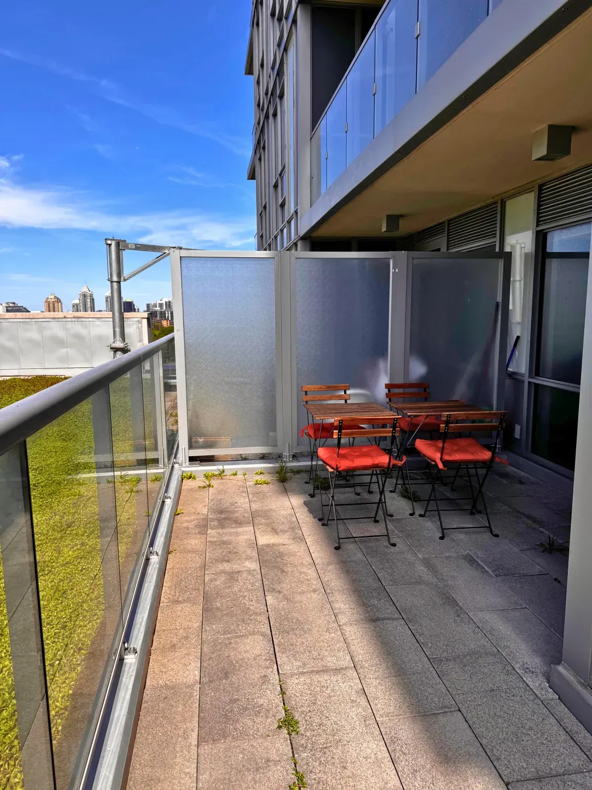 Expansive private walk-out terrace at 120 Harrison Garden Blvd #901 with wood decking and garden views.