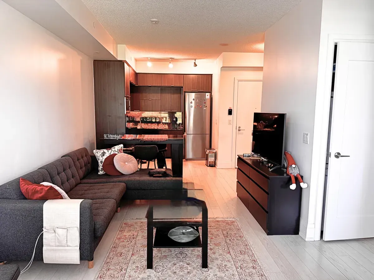 Sun-filled living area at 120 Harrison Garden Blvd #901 featuring floor-to-ceiling windows and modern wide-plank flooring.