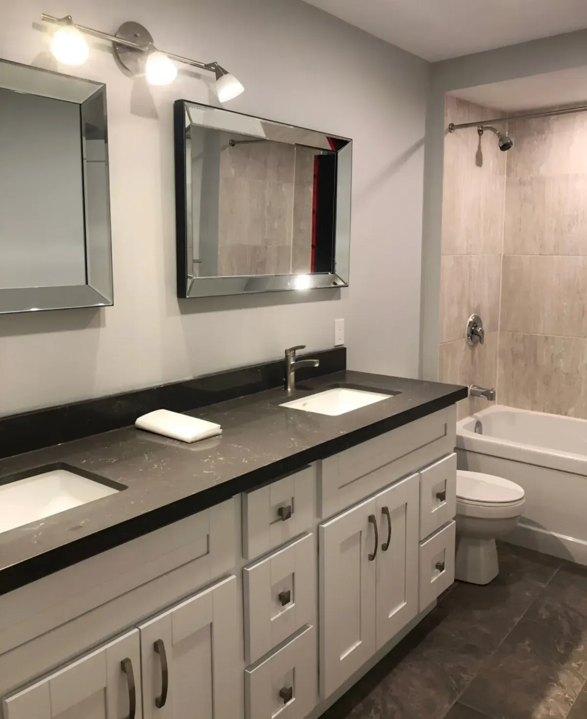 Luxury bathroom at 36 Branstone Rd #1 featuring a double sink vanity, large mirrors, and modern light fixtures.