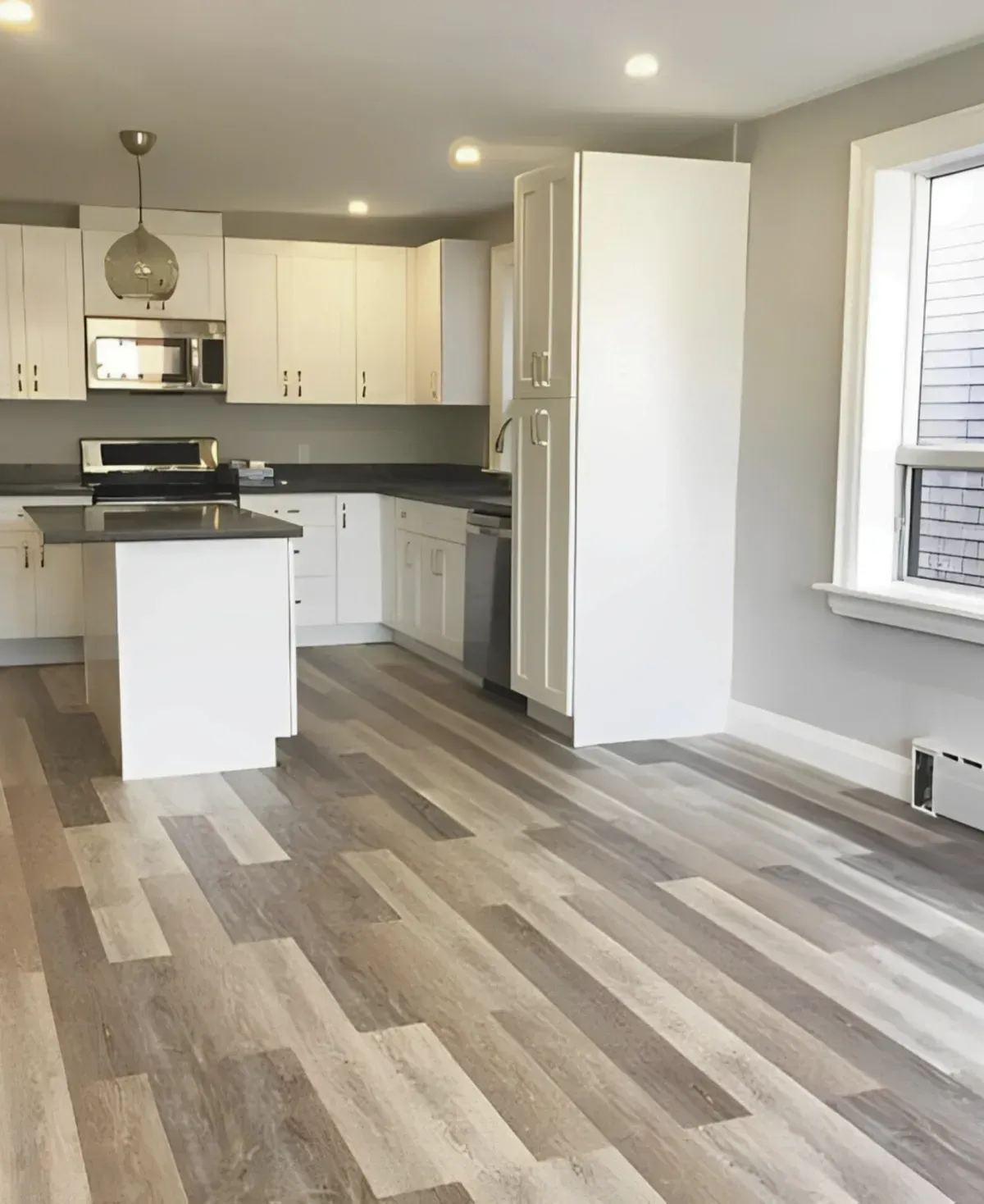 Modern kitchen at 36 Branstone Rd #1 featuring white cabinetry, quartz countertops, a central island, and stainless steel appliances.