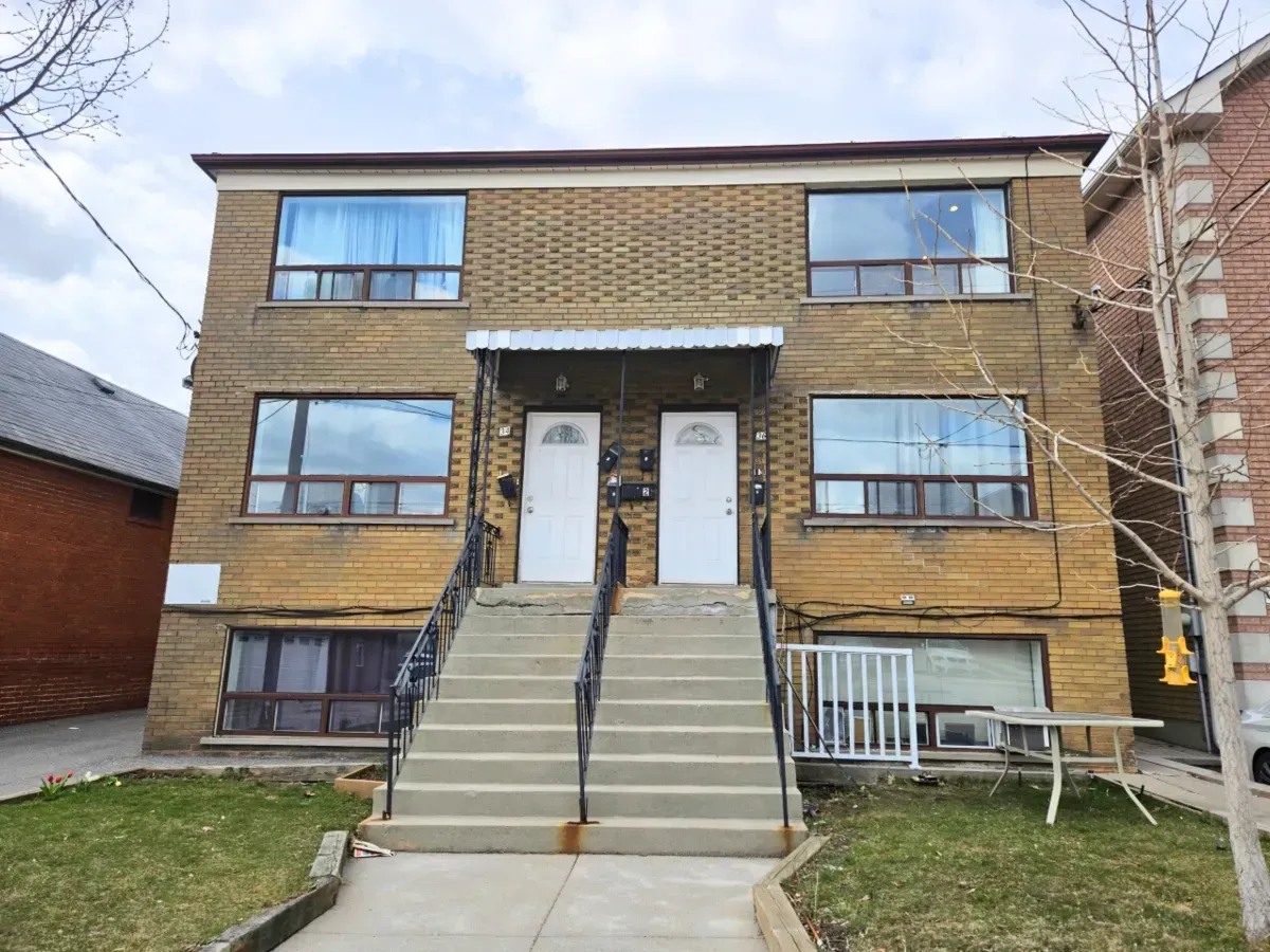 Main floor unit entrance with professional landscaping and a secure concrete staircase.
