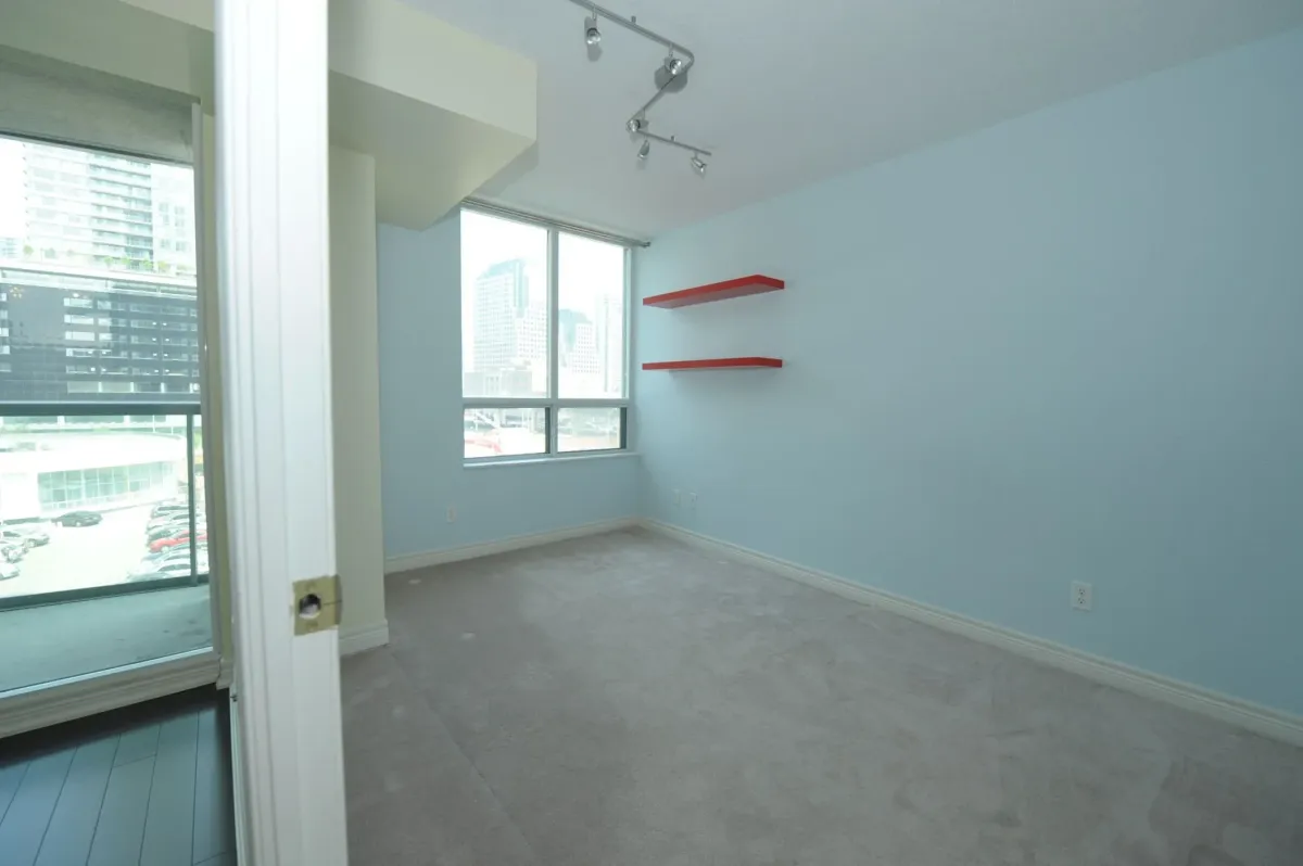 Primary bedroom with large windows and split-bedroom layout at 30 Grand Trunk Crescent Unit 509 Toronto.