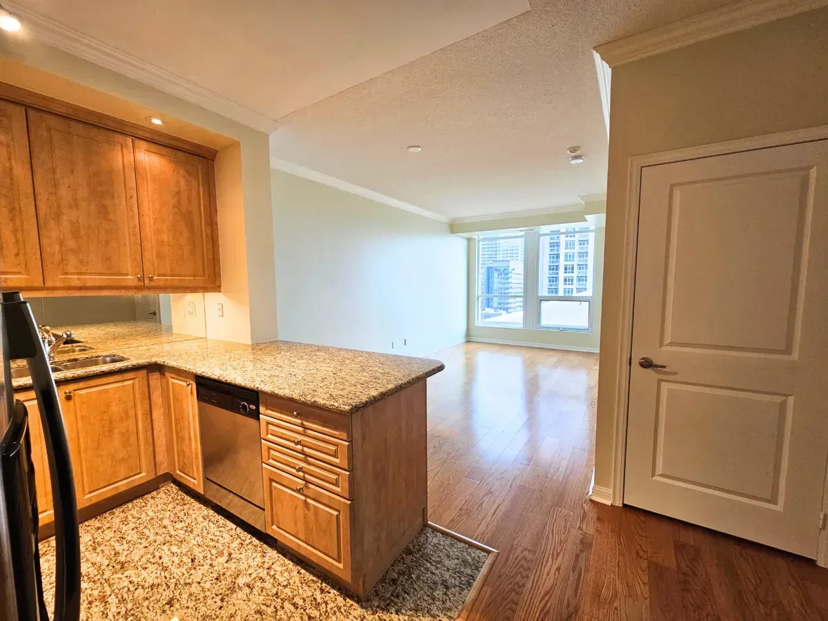 Open-concept kitchen with rich cabinetry and premium stone counters in a West Harbour City condo.