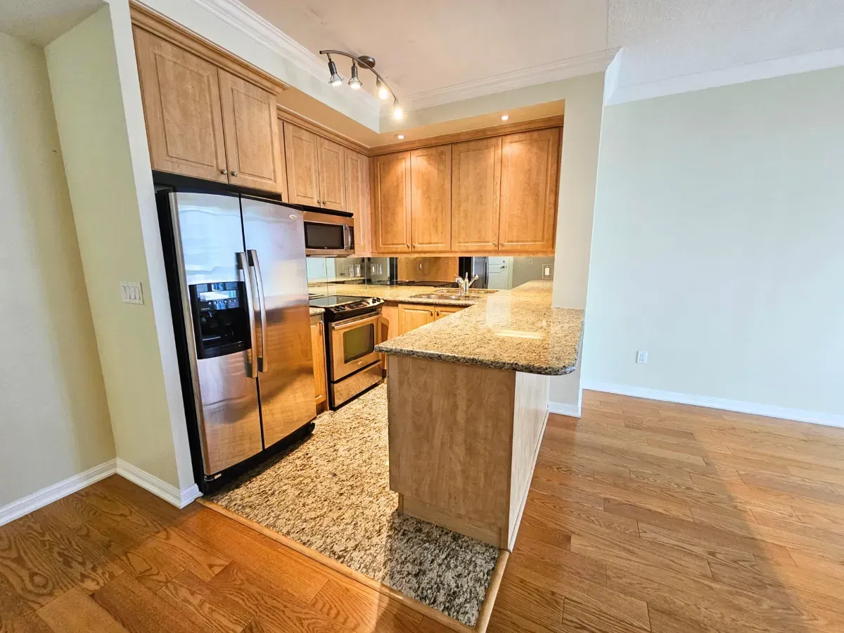 Modern kitchen at 628 Fleet St #1311 featuring granite countertops, a breakfast bar, and stainless steel appliances.