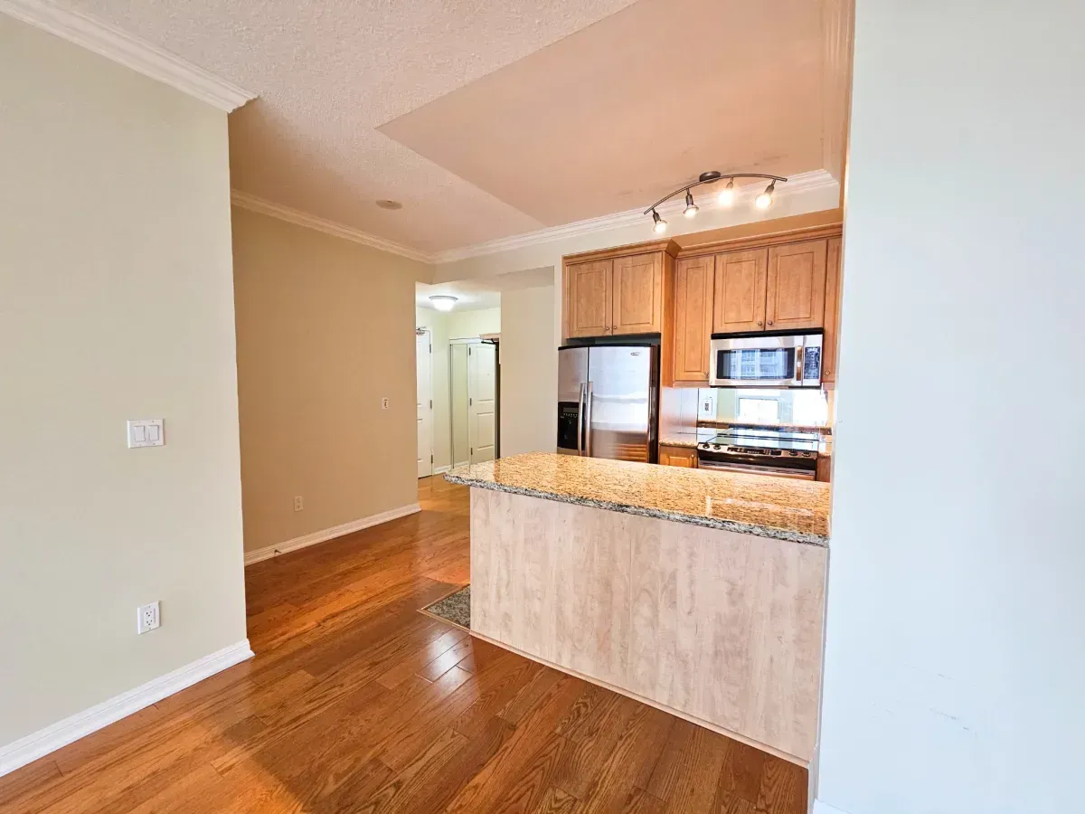Open-concept kitchen with rich cabinetry and premium stone counters in a West Harbour City condo.