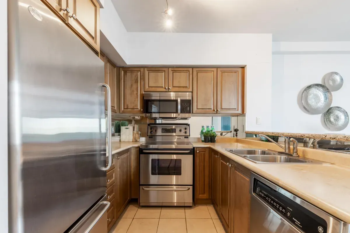 Modern kitchen with a breakfast bar overlooking the dining area and balcony at 5 Marine Parade Dr #630, Etobicoke.