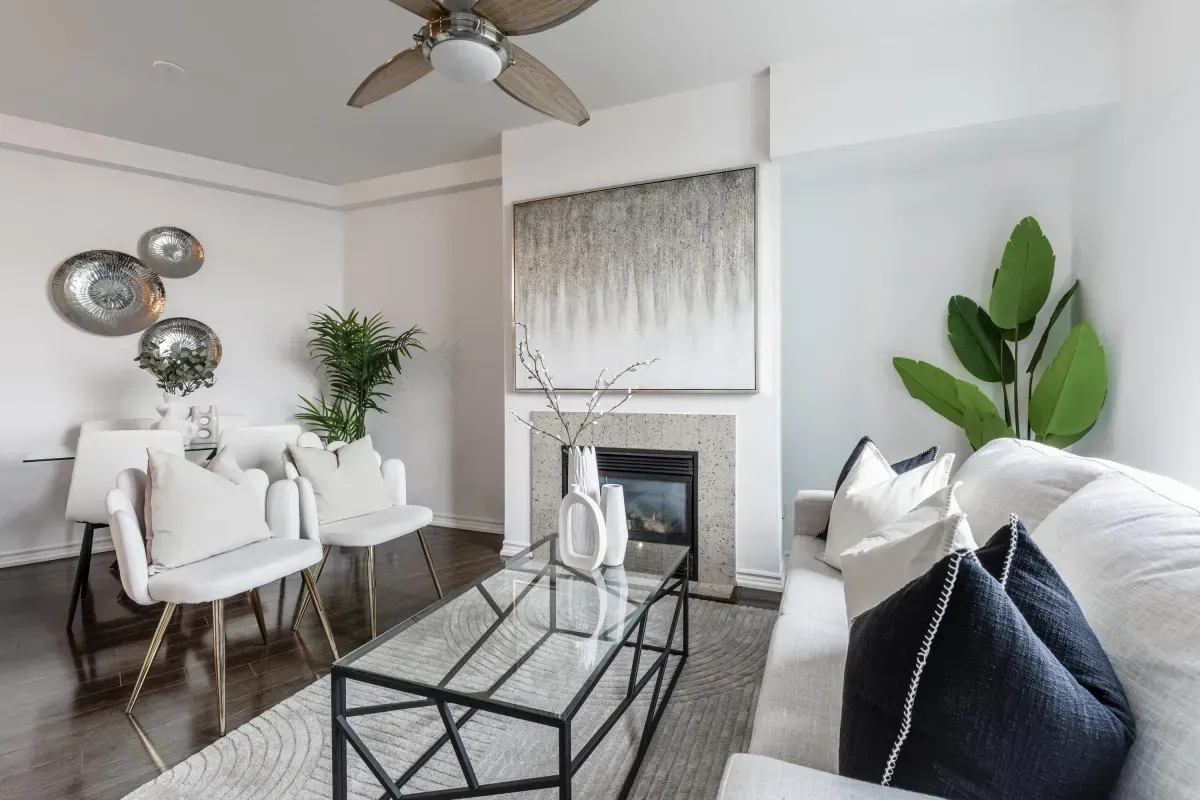 Bright living area at 5 Marine Parade Dr #630, Etobicoke, featuring a cozy gas fireplace, hardwood floors, and a ceiling fan.