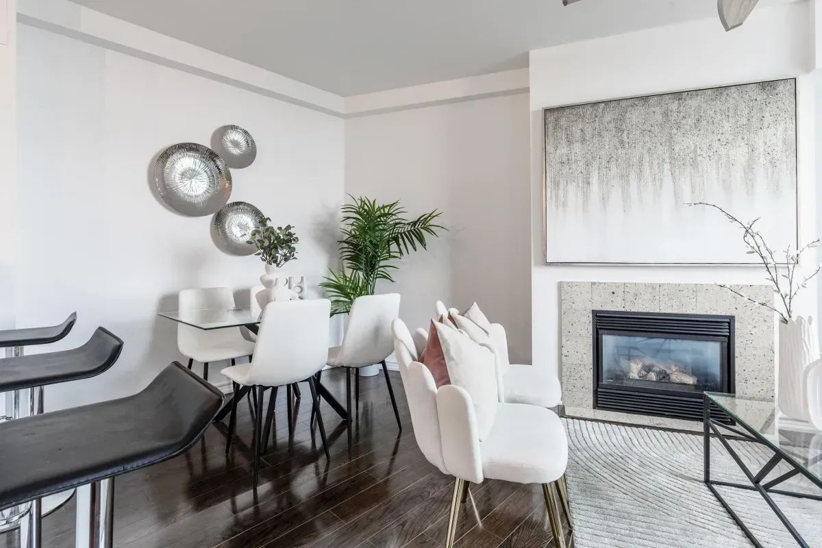 Bright living area at 5 Marine Parade Dr #630, Etobicoke, featuring a cozy gas fireplace, hardwood floors, and a ceiling fan.