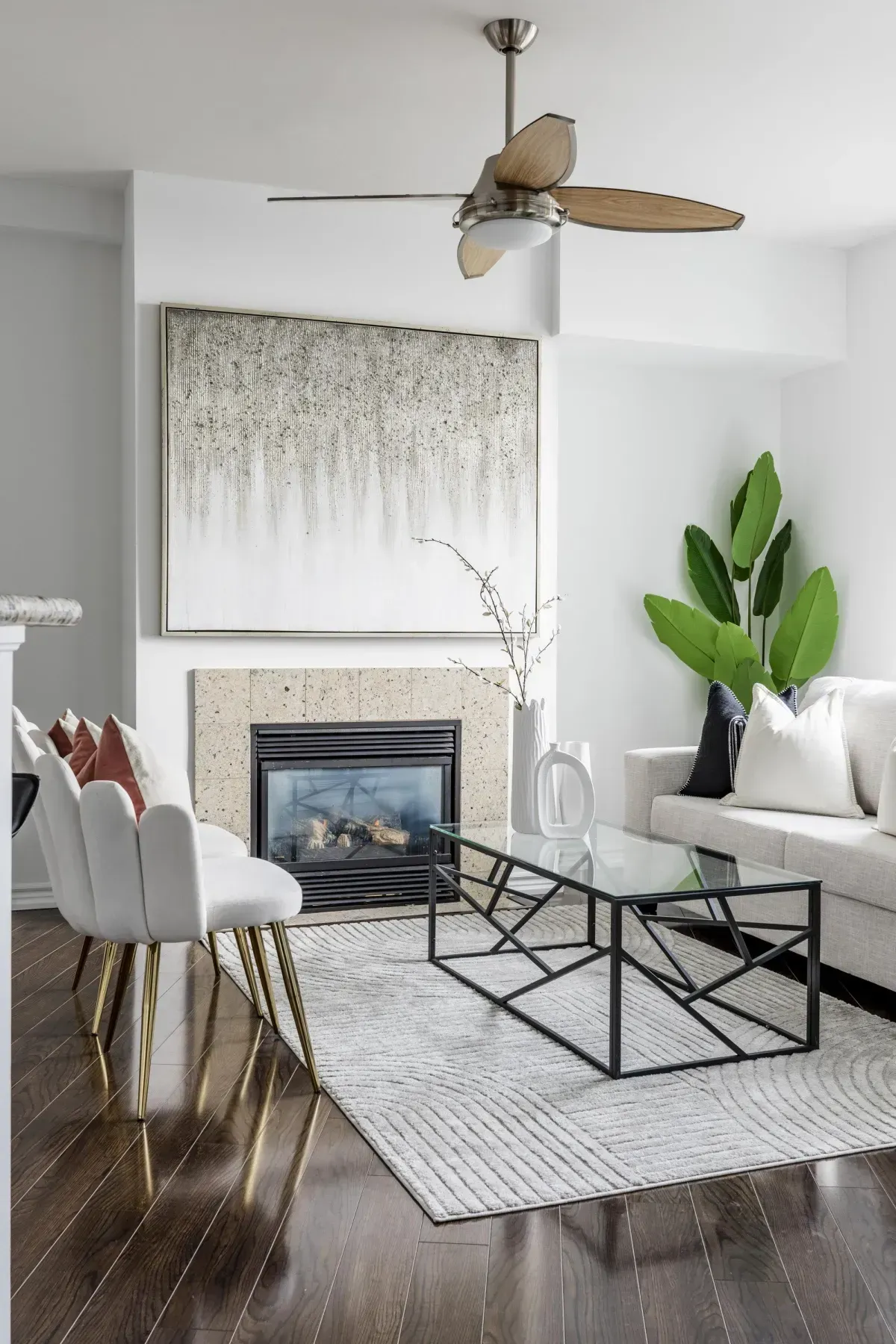 Bright living area at 5 Marine Parade Dr #630, Etobicoke, featuring a cozy gas fireplace, hardwood floors, and a ceiling fan.